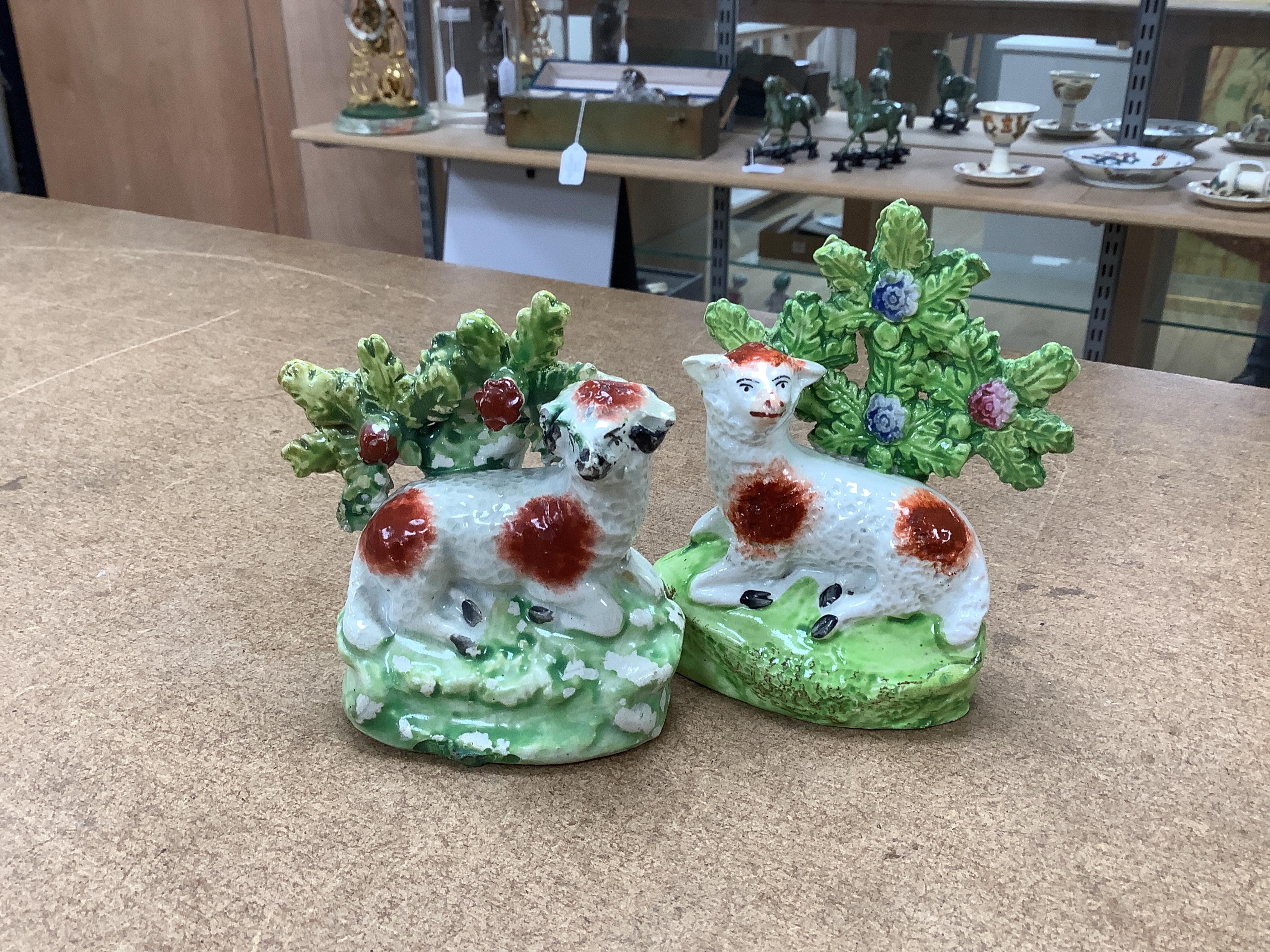 A pair of early 19th century pearlware models of sheep, an English porcelain ‘sheep’ ring tree and a Derby figure of a cherub, tallest 10 cm. Condition - ring tree restored the others fair to good